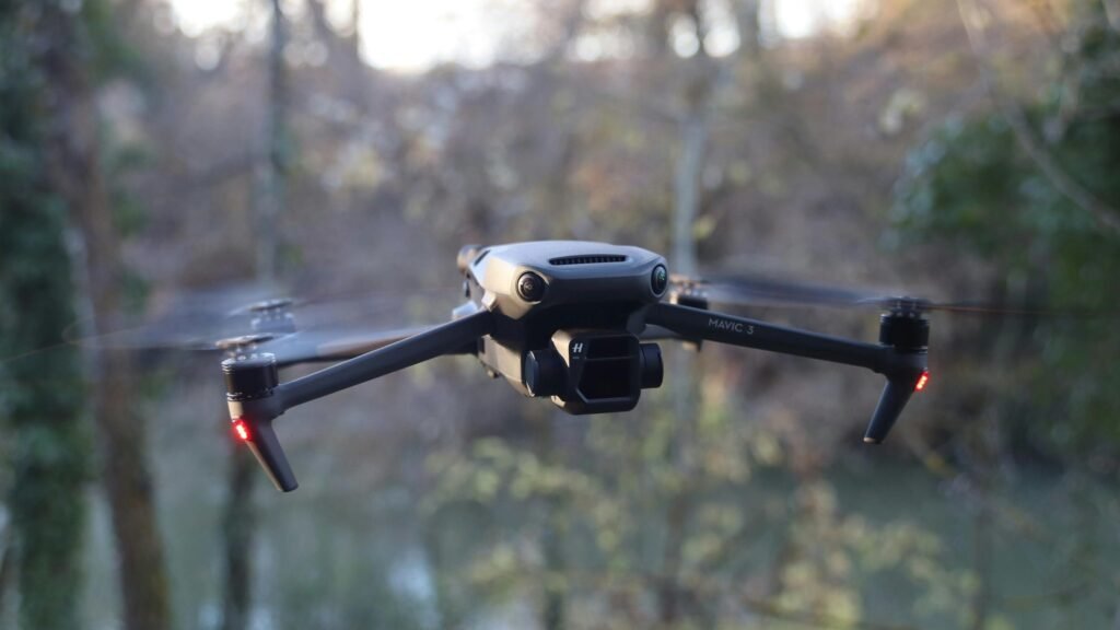 DJI Mavic 3 drone in flight over scenic forested area.